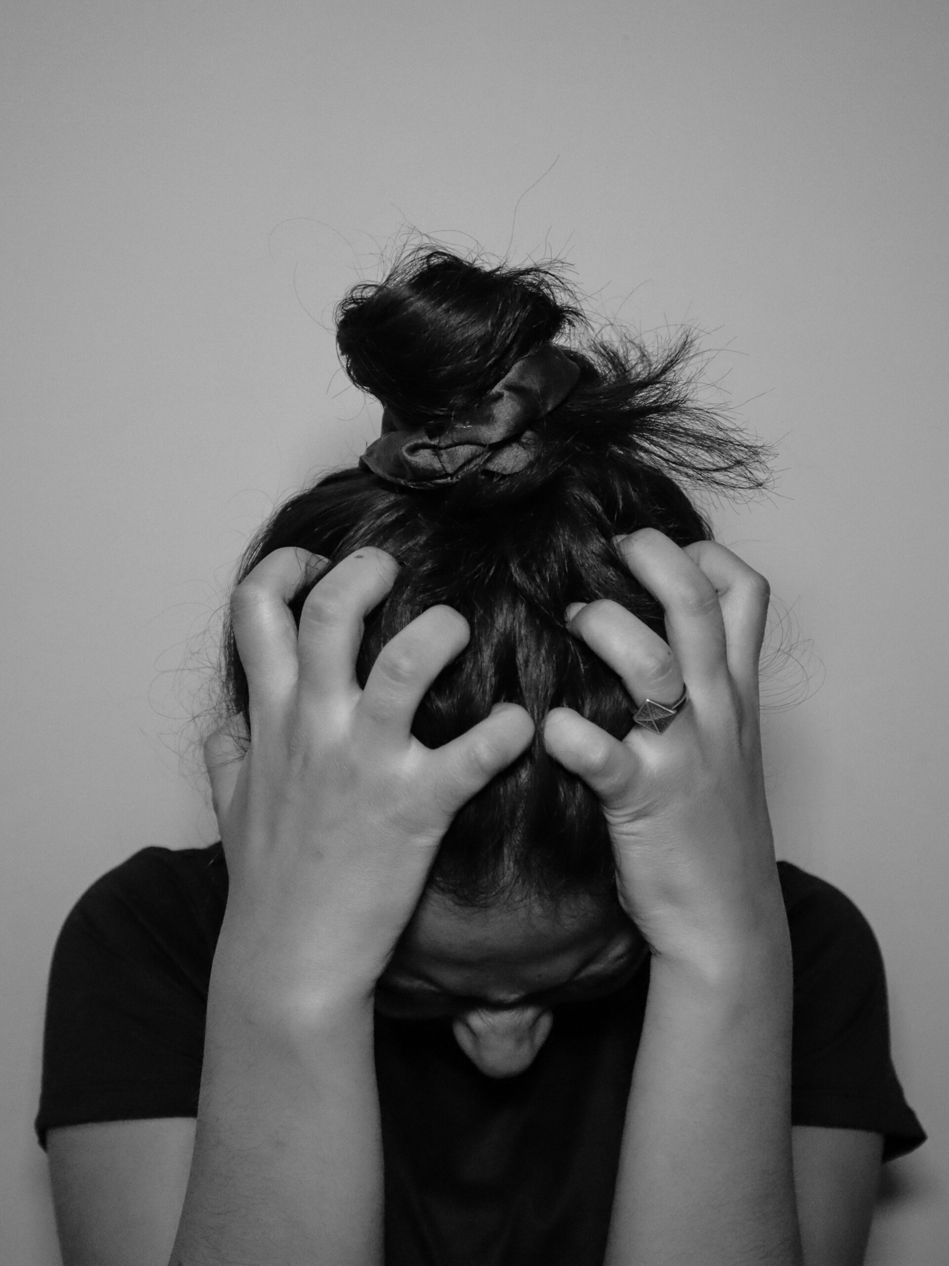 "A woman holding her head in distress, symbolizing emotional overwhelm and anxiety."