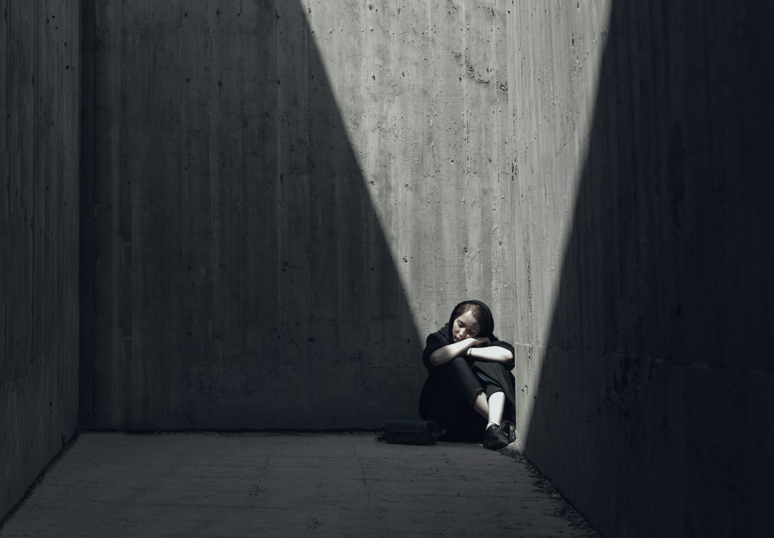 A lonely person sitting in a dark corner, symbolizing anxiety, depression, and mental health struggles.
